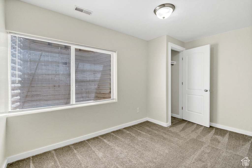 Carpeted spare room with baseboards