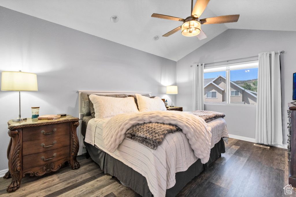 Bedroom featuring lofted ceiling, wood finished floors, baseboards, and a ceiling fan