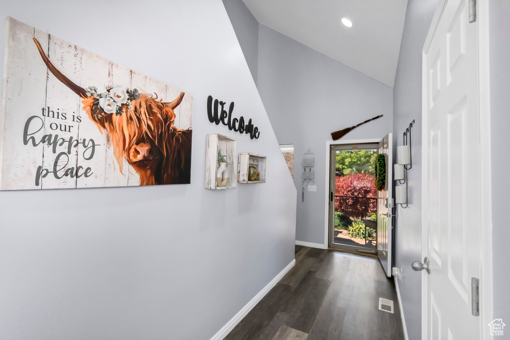 Foyer entrance with wood finished floors, baseboards, high vaulted ceiling, and recessed lighting