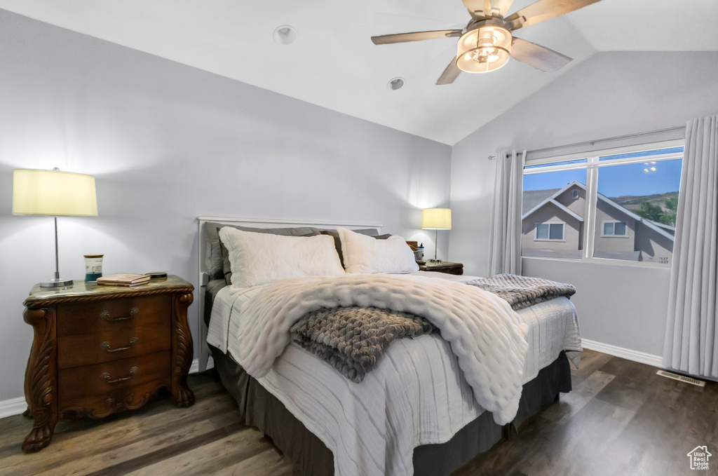Bedroom with lofted ceiling, wood finished floors, baseboards, and ceiling fan