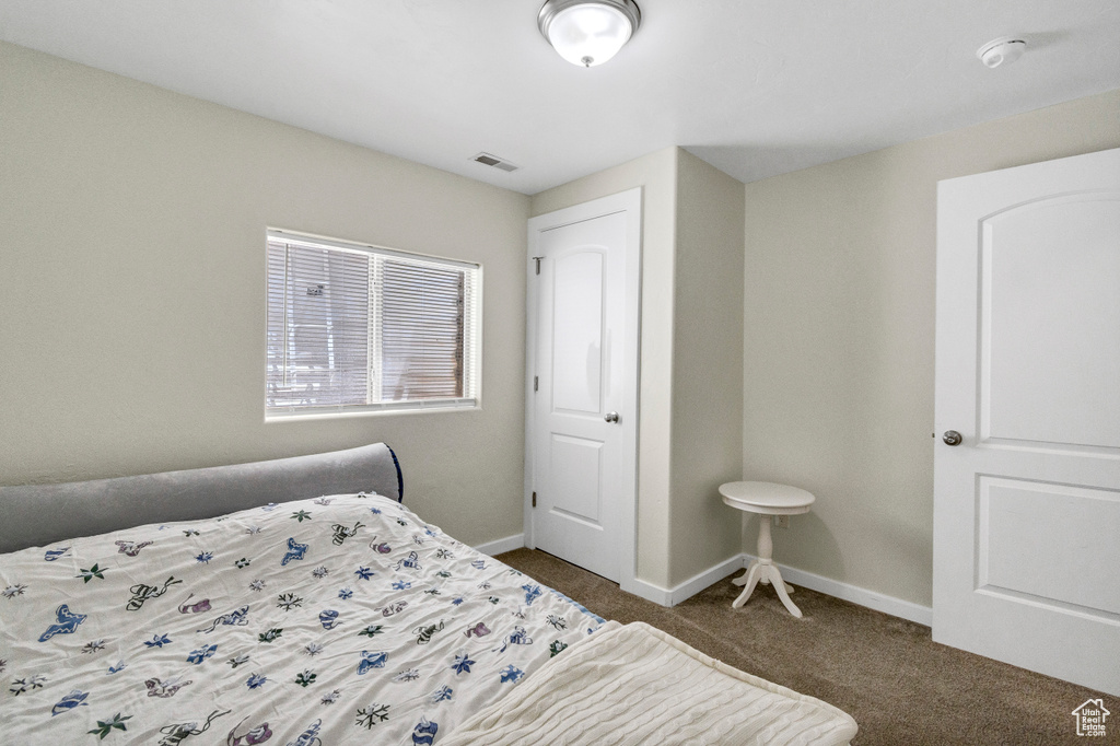 Bedroom with dark carpet and baseboards