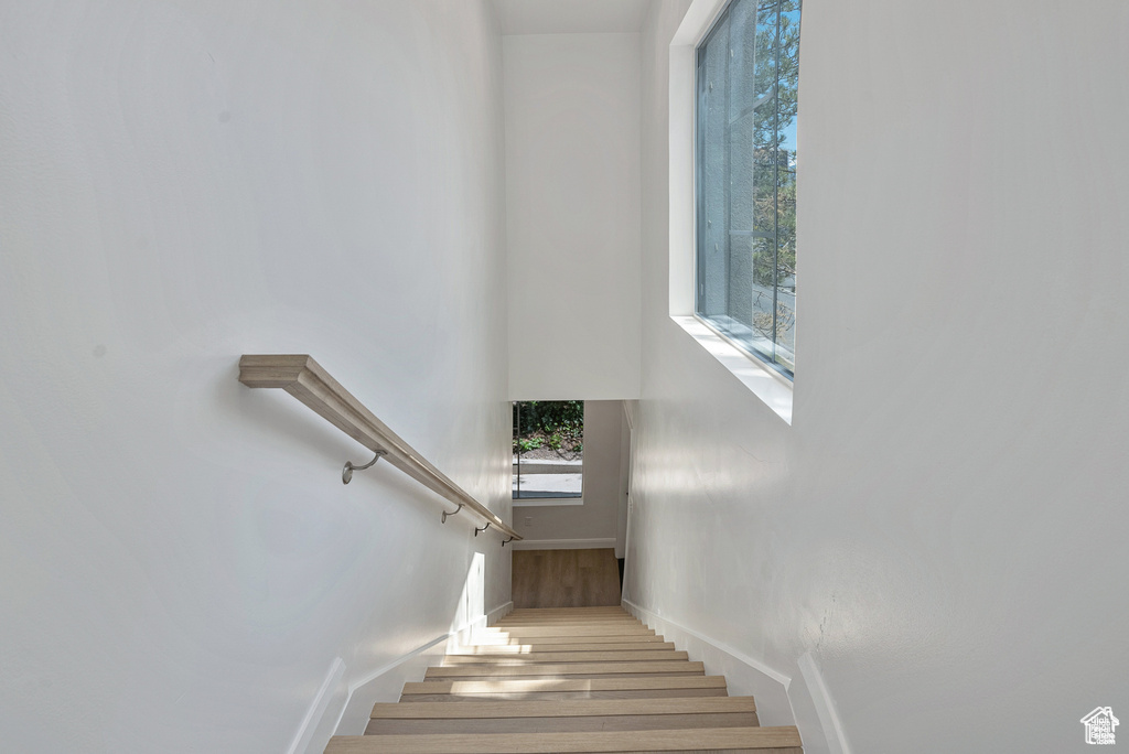 Staircase with wood finished floors and baseboards