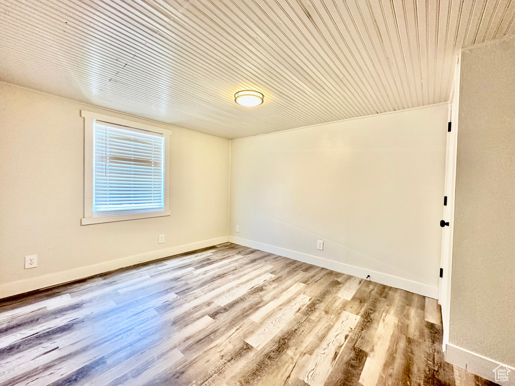 Spare room featuring wood ceiling, wood finished floors, and baseboards