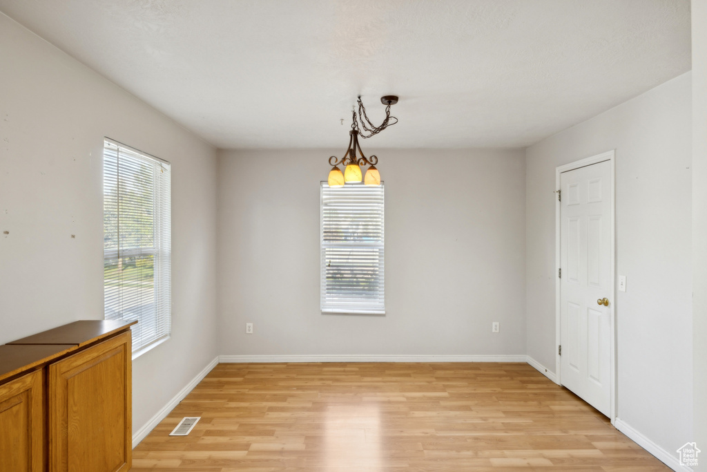 Unfurnished dining area with light wood-type flooring and baseboards