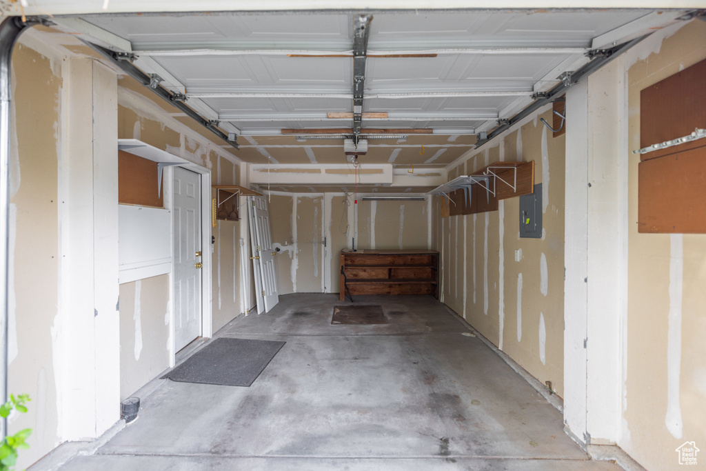Garage featuring electric panel and a garage door opener