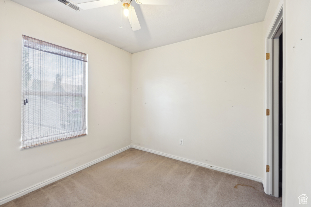 Unfurnished room with light carpet, baseboards, and ceiling fan