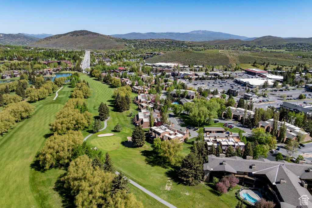 Aerial overview of property's location with a local golf course, a water and mountain view, and nearby suburban area