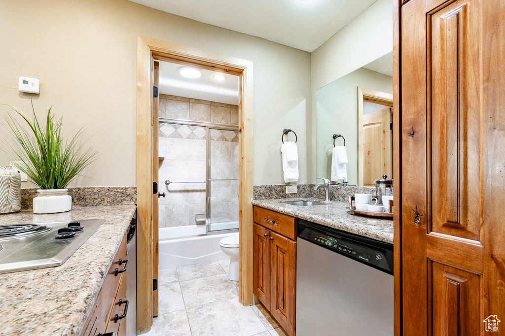 Bathroom with toilet, vanity, and enclosed tub / shower combo