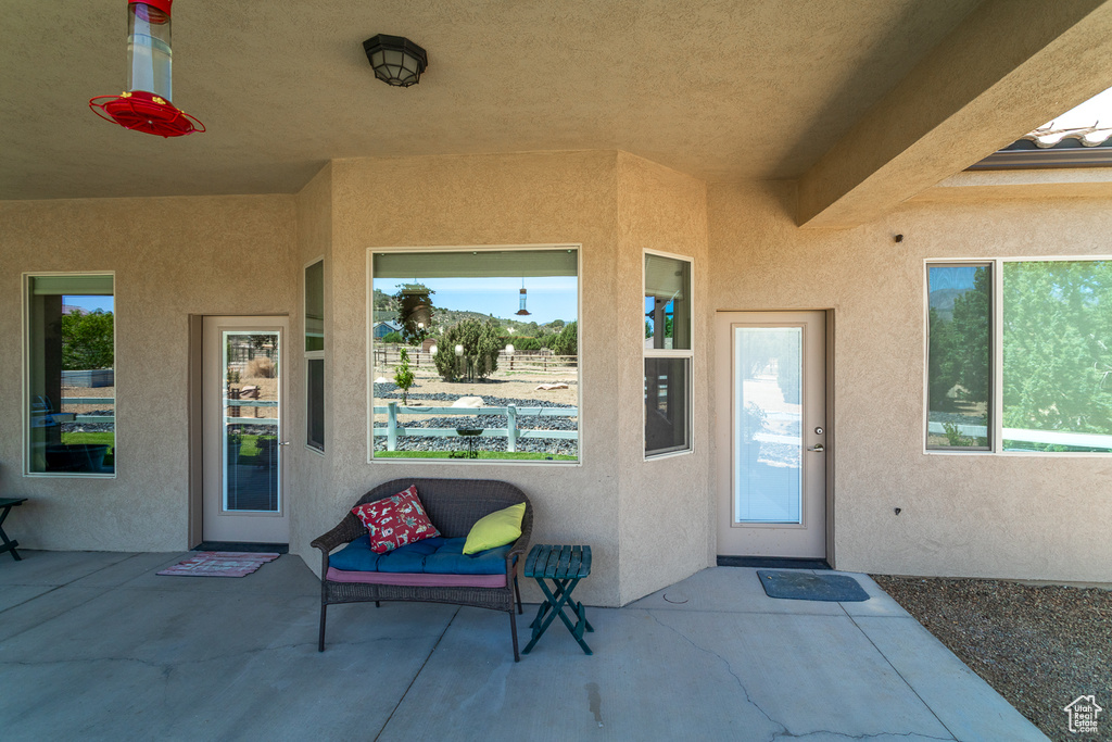 Doorway to property featuring stucco siding and a patio area