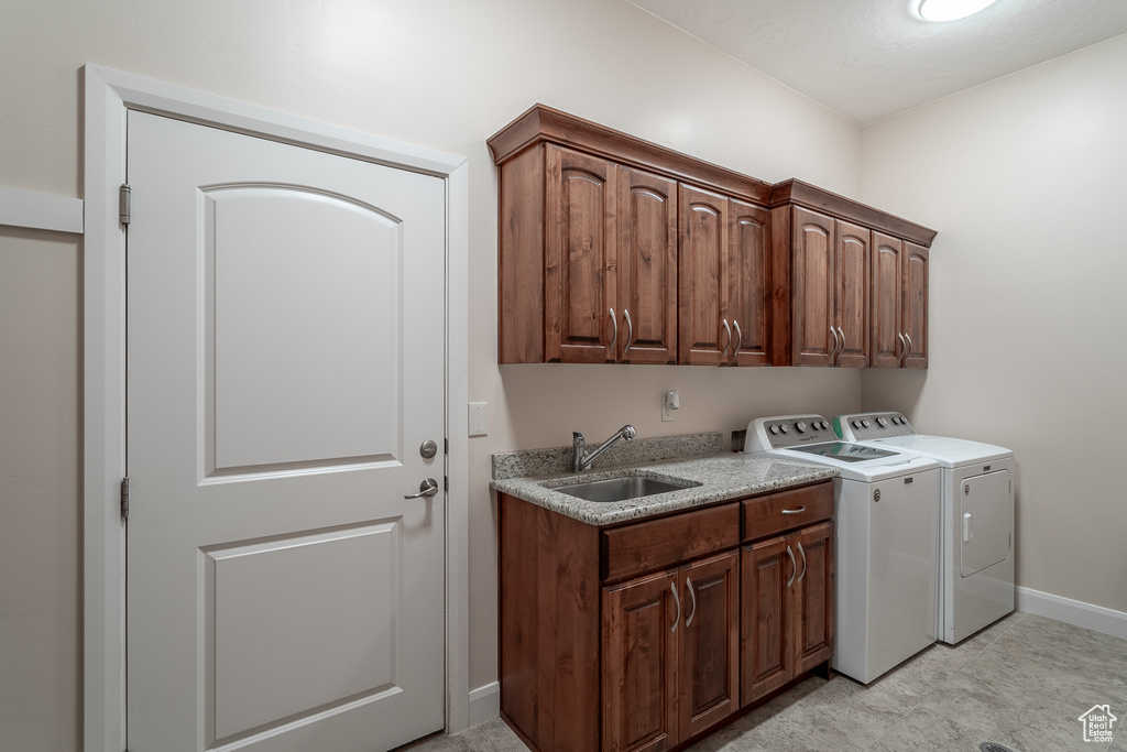 Laundry room with washer and dryer, cabinet space, and baseboards