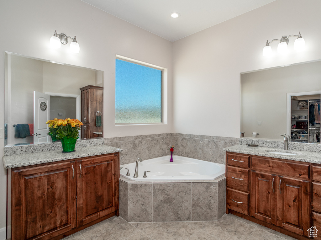 Full bathroom featuring vanity, a bath, and tile patterned flooring