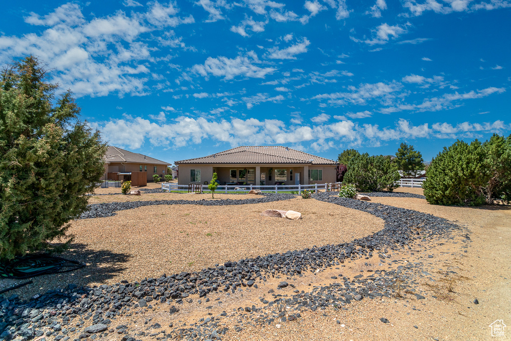 Back of property featuring a tile roof and stucco siding
