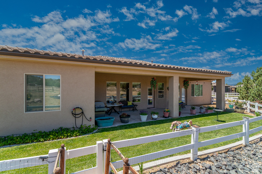 View of front of house with stucco siding, a patio area, and a tile roof