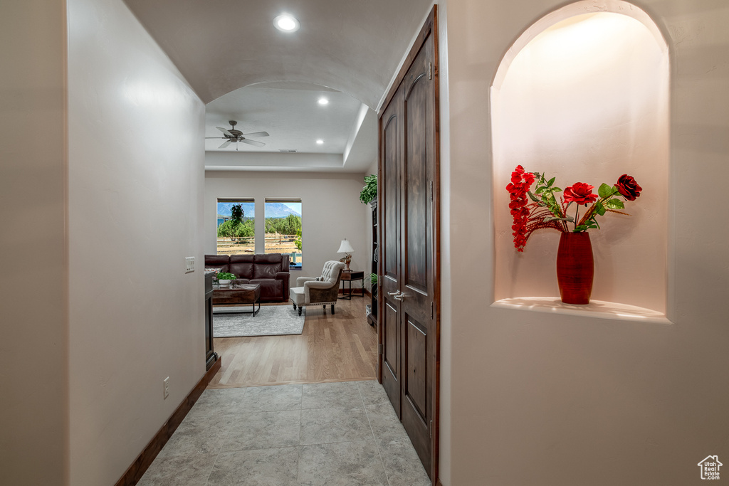 Hall with recessed lighting, baseboards, and a tray ceiling