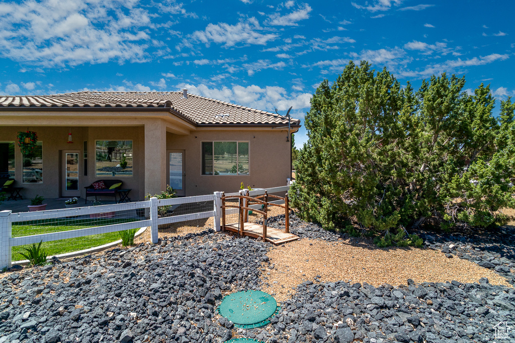 View of property exterior with a tile roof and stucco siding