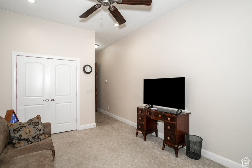 Living area with ceiling fan, light colored carpet, and baseboards