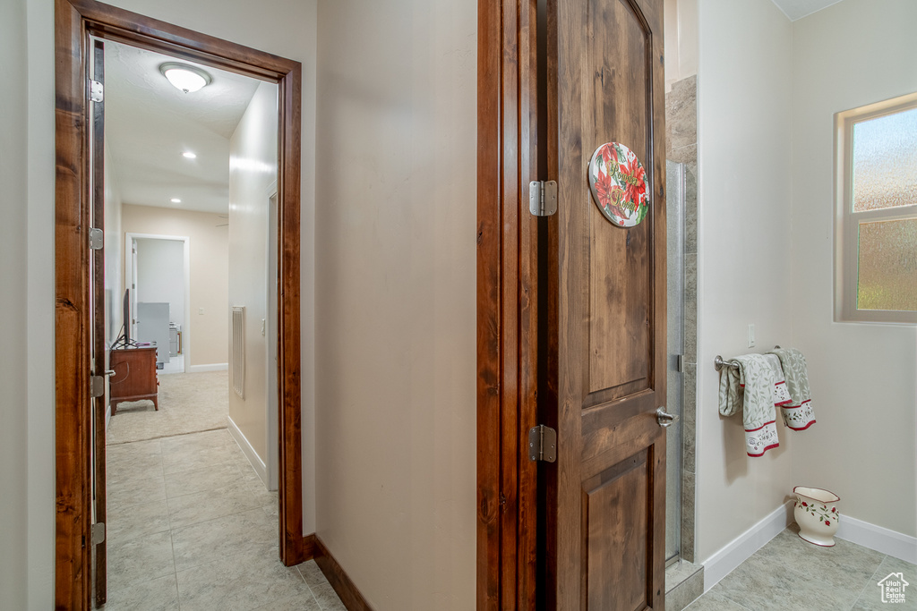 Corridor featuring baseboards, light tile patterned floors, and recessed lighting