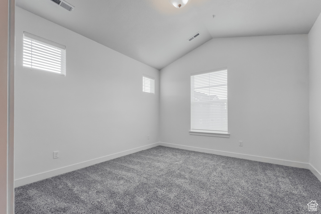 Spare room with lofted ceiling, carpet, and baseboards