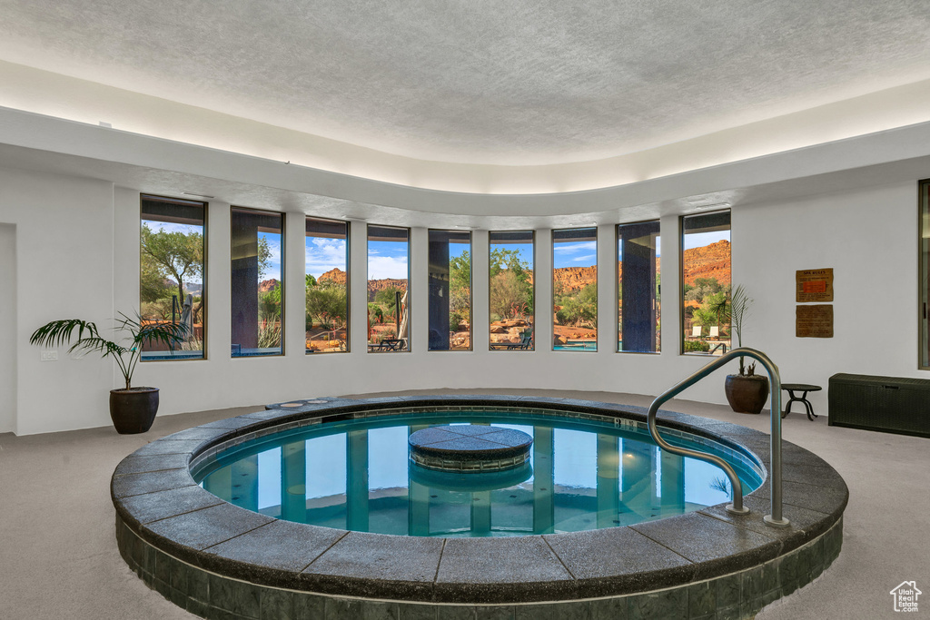 Indoor pool featuring a jacuzzi