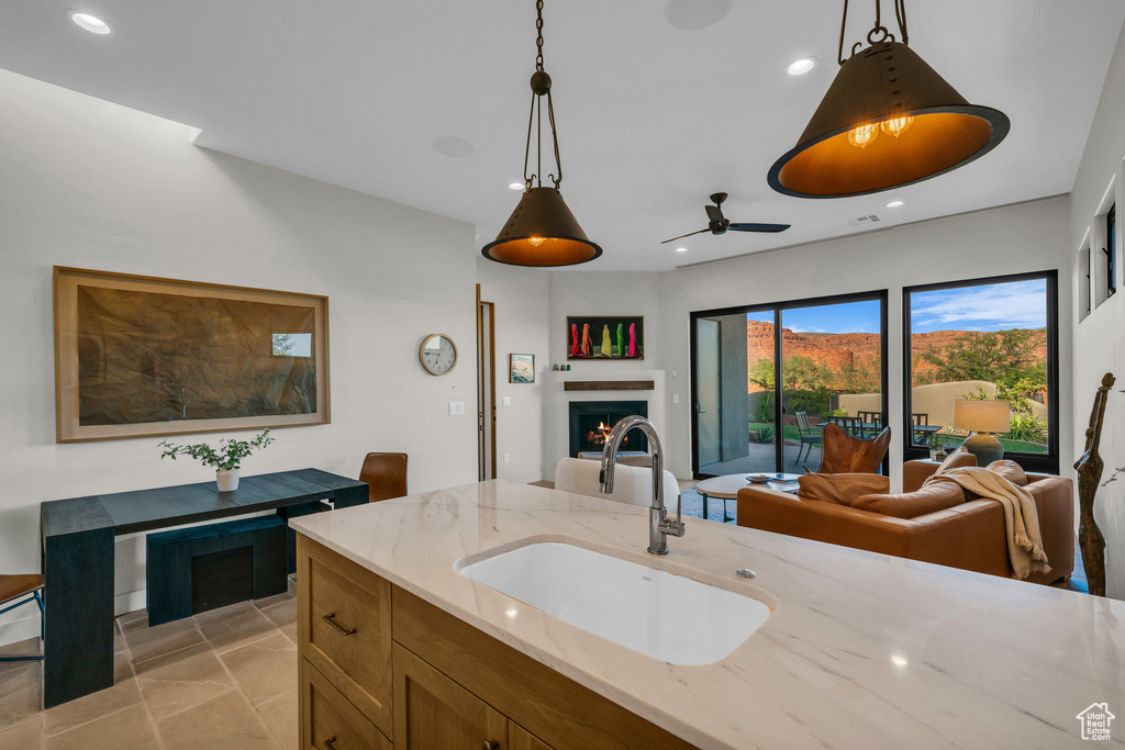Kitchen with a sink, open floor plan, a ceiling fan, recessed lighting, and hanging light fixtures