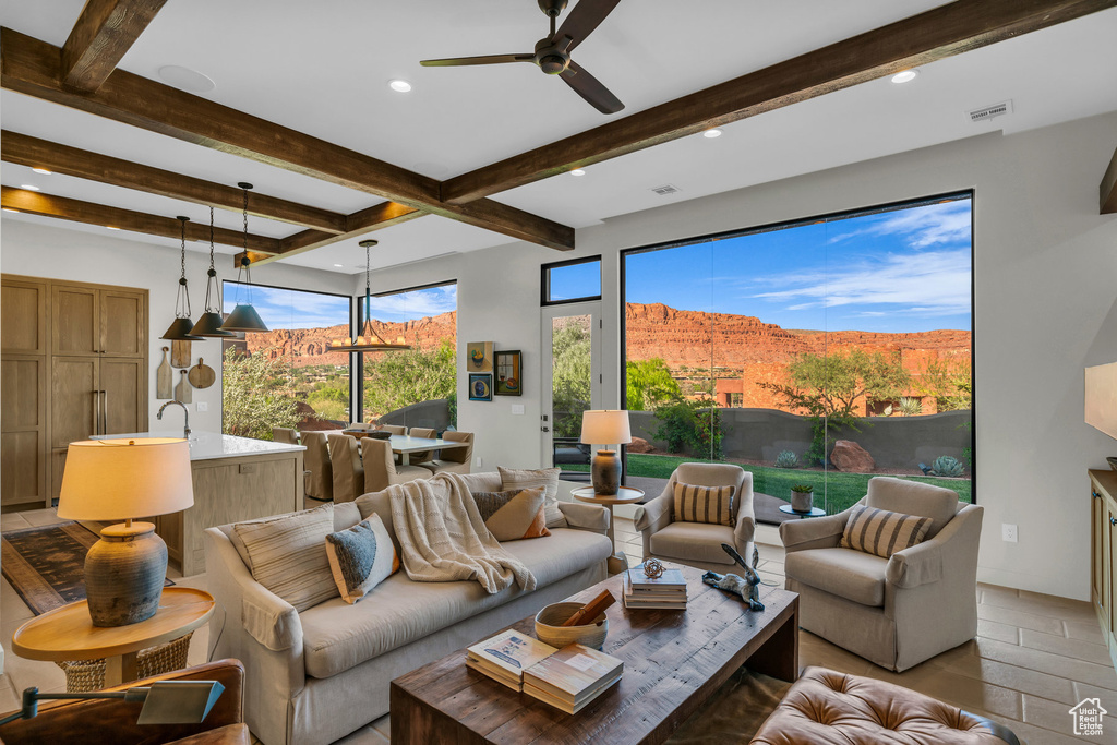 Living area with beam ceiling, ceiling fan, recessed lighting, and a mountain view
