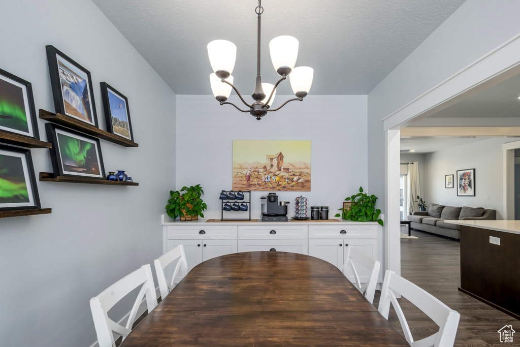 Dining room featuring a chandelier and dark wood-style floors