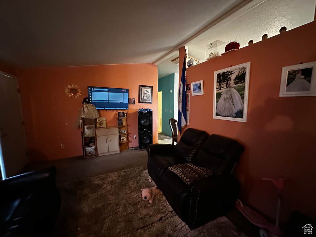 Carpeted living room with lofted ceiling