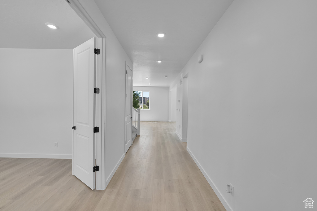 Corridor featuring light wood-style floors, recessed lighting, and baseboards