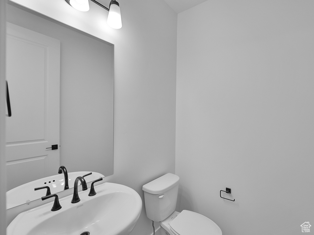 Half bath featuring toilet and a sink