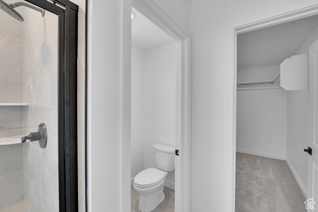 Full bath featuring a shower stall, toilet, and baseboards
