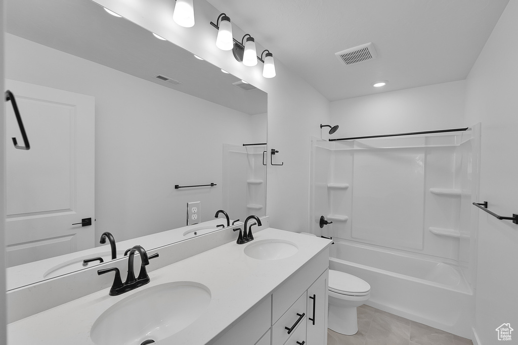 Bathroom with double vanity, toilet, tub / shower combination, and tile patterned floors