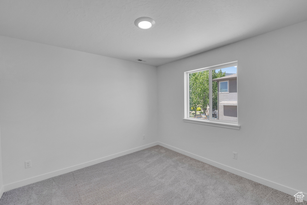 Carpeted empty room with baseboards