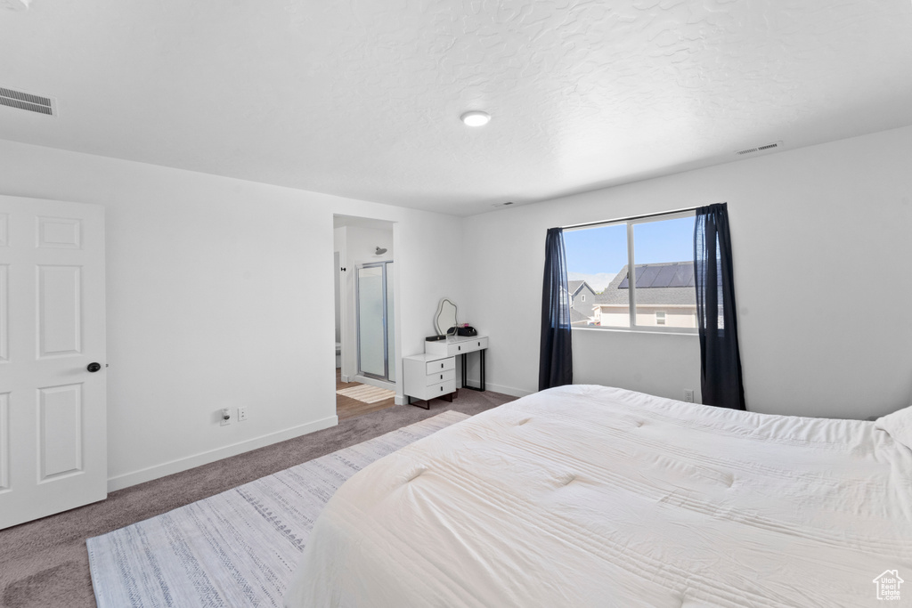 Bedroom with baseboards, carpet flooring, and connected bathroom