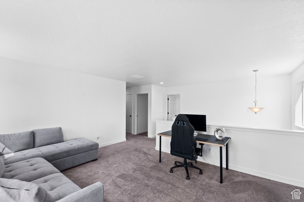 Carpeted home office featuring baseboards