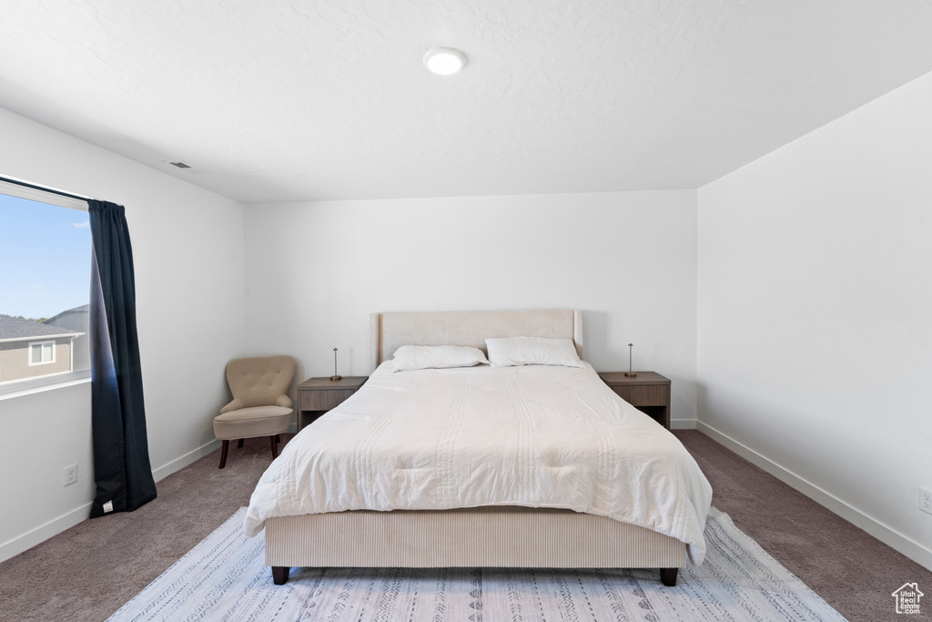 Bedroom featuring light colored carpet and baseboards