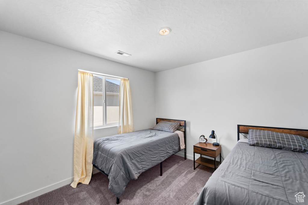 Bedroom featuring carpet flooring and baseboards