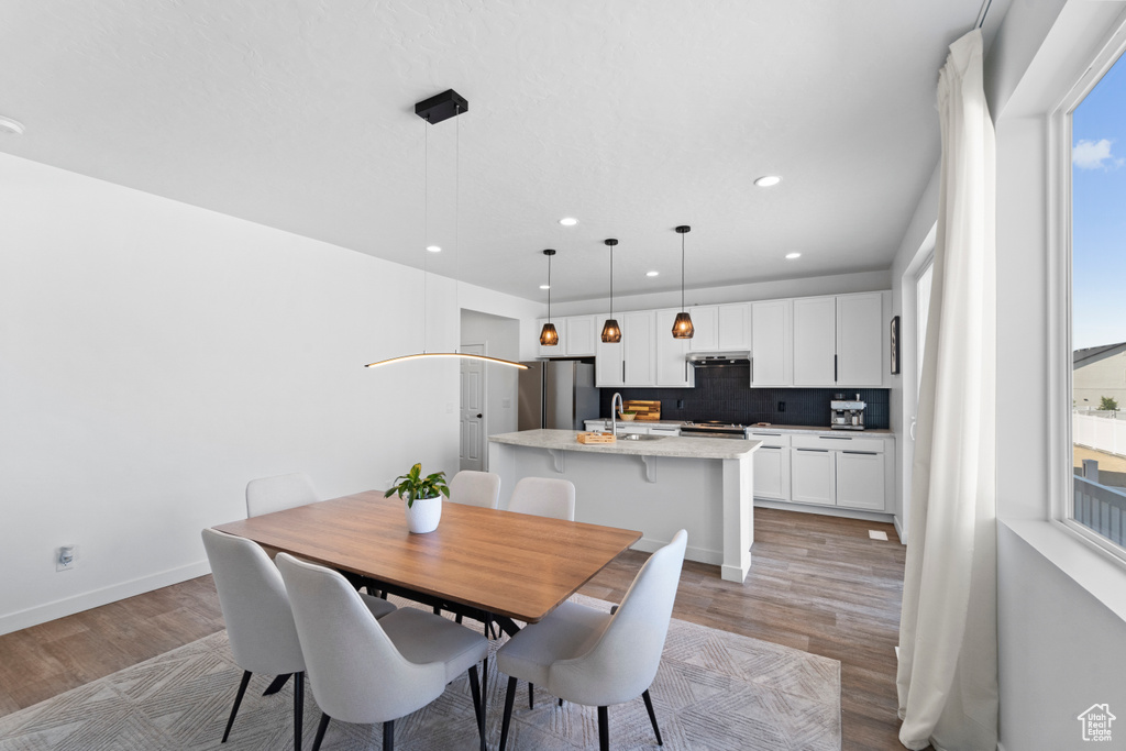 Dining space with light wood-type flooring, recessed lighting, and baseboards