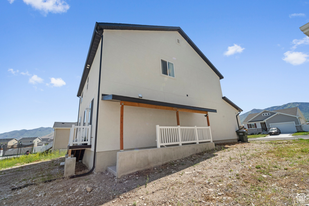 Back of house featuring a mountain view and stucco siding