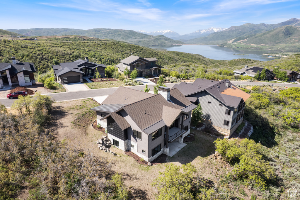 Aerial view of property and surrounding area featuring a water and mountain view