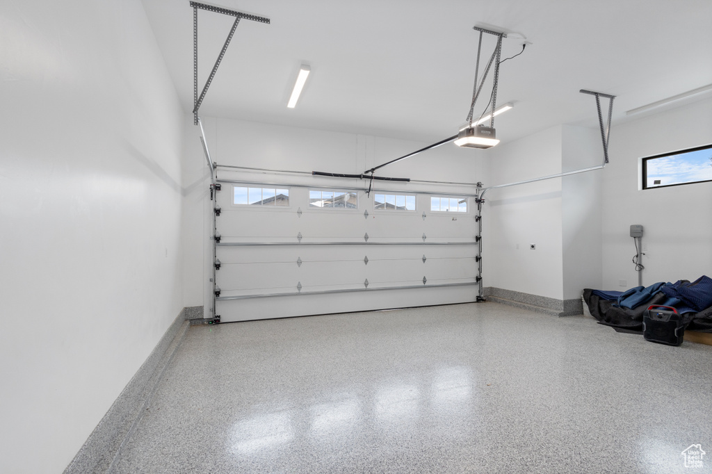 Garage with a garage door opener and baseboards