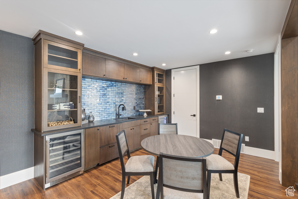 Indoor wet bar with beverage cooler, baseboards, dark wood finished floors, and recessed lighting