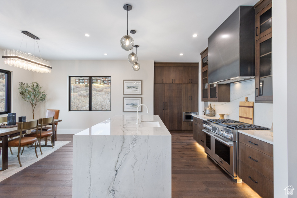 Kitchen with double oven range, range hood, a sink, recessed lighting, and dark wood finished floors