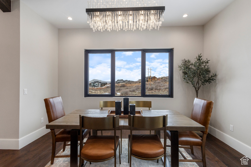 Dining space with baseboards, wood finished floors, a chandelier, and recessed lighting