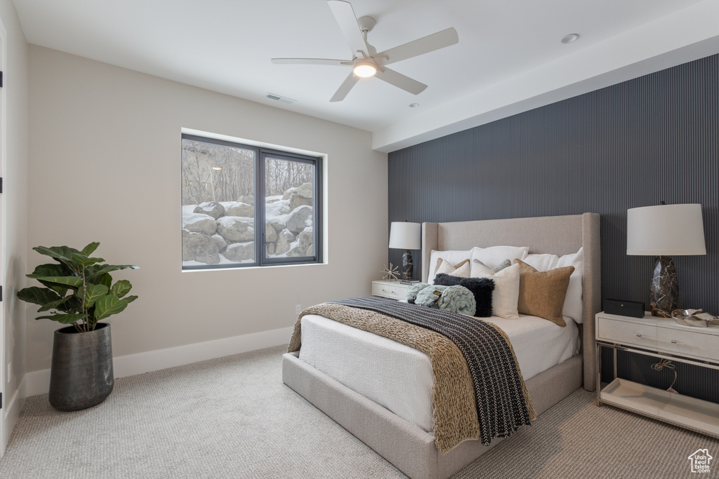 Carpeted bedroom with ceiling fan and baseboards