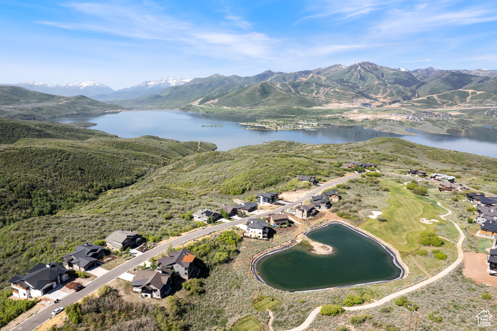 Aerial overview of property's location featuring a water and mountain view and nearby suburban area