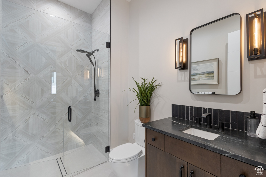 Full bathroom with toilet, vanity, and a stall shower