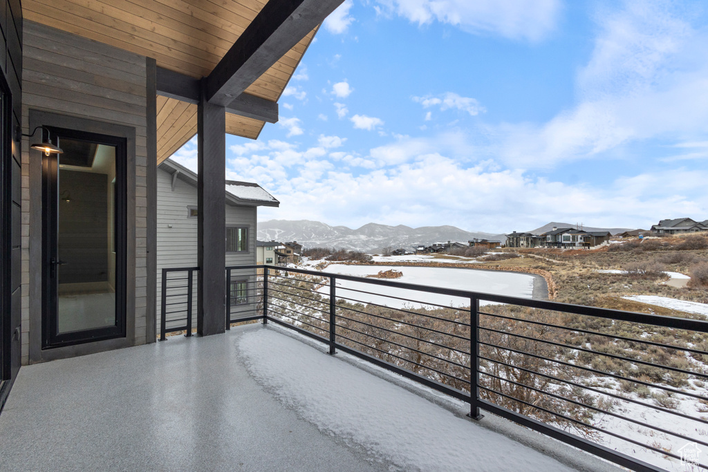 Snow covered back of property with a mountain view