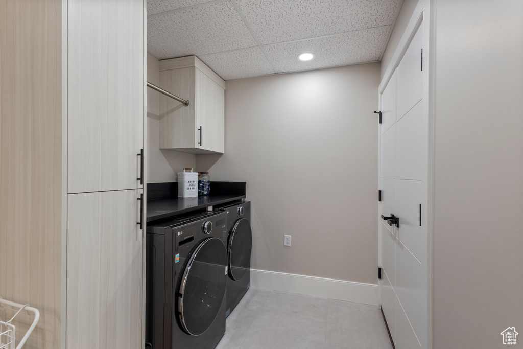 Laundry area featuring cabinet space, washer and dryer, recessed lighting, baseboards, and light tile patterned flooring