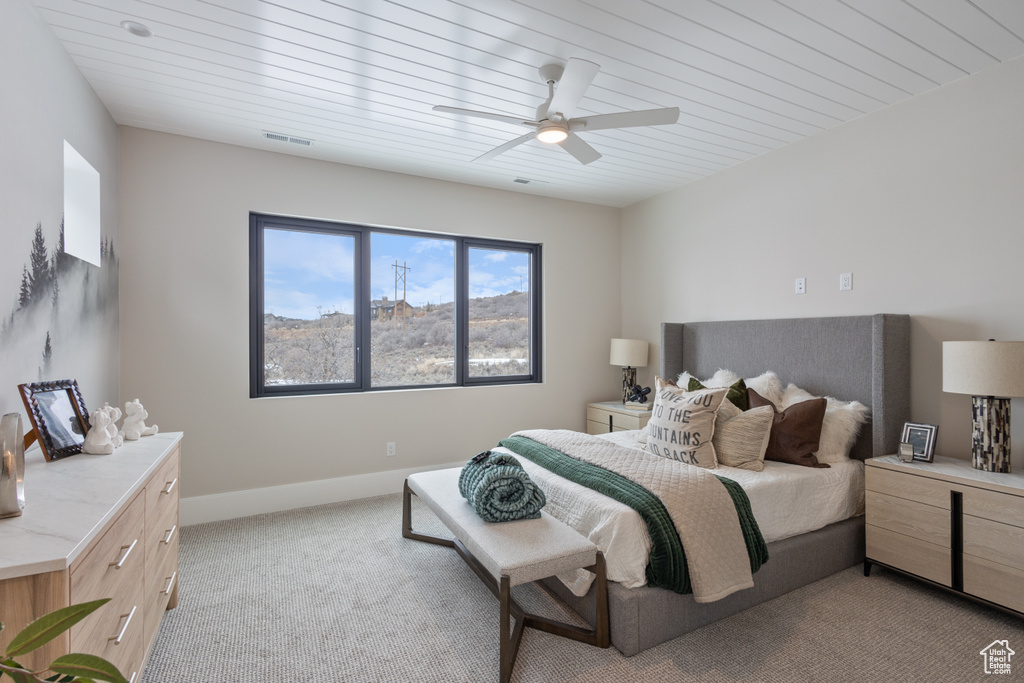 Bedroom featuring light colored carpet, a ceiling fan, and baseboards