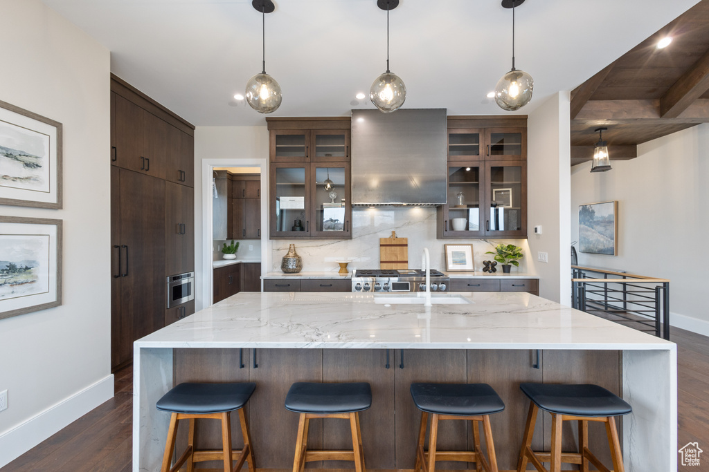 Kitchen featuring baseboards, exhaust hood, dark wood-type flooring, a sink, and recessed lighting